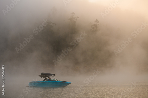beautiful side view of bright motorboat on water covered with fog.