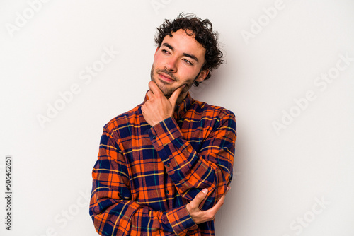 Young caucasian man isolated on white background thinking and looking up, being reflective, contemplating, having a fantasy.