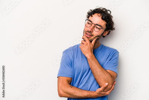 Young caucasian man isolated on white background relaxed thinking about something looking at a copy space.