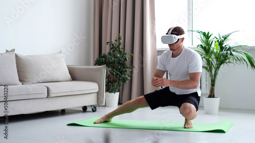 Canvas Print young man in sports clothing doing squat while wearing virtual reality glasses