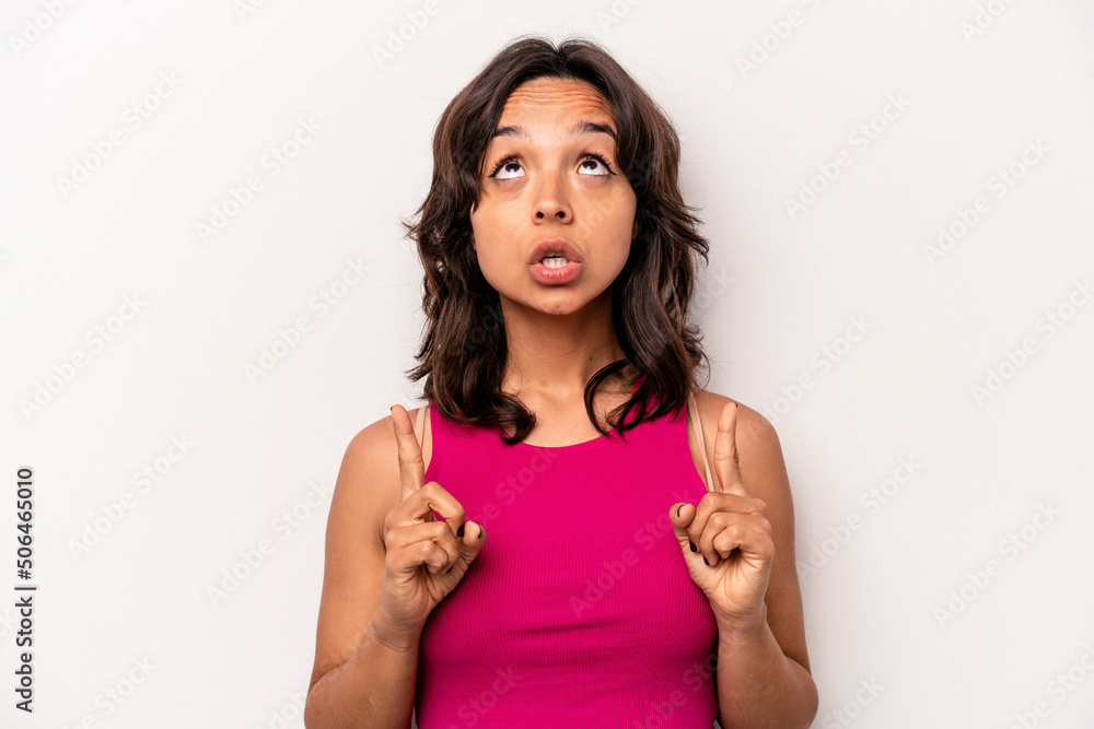 Young hispanic woman isolated on white background pointing upside with opened mouth. Young hispanic woman isolated on white background pointing upside with opened mouth.