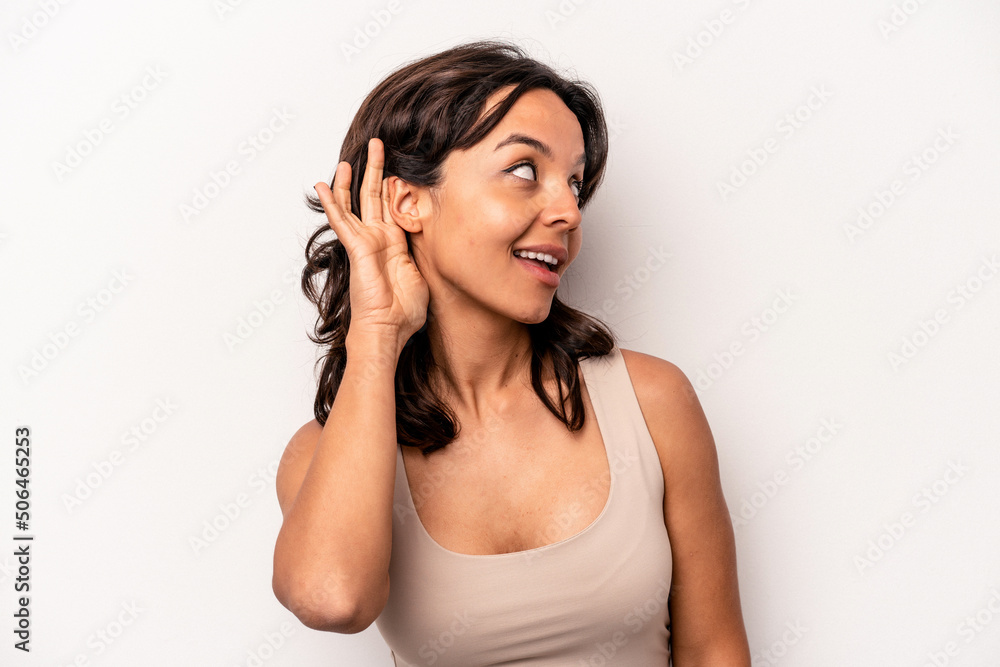 Young hispanic woman isolated on white background trying to listening a gossip. Young hispanic woman isolated on white background trying to listening a gossip.