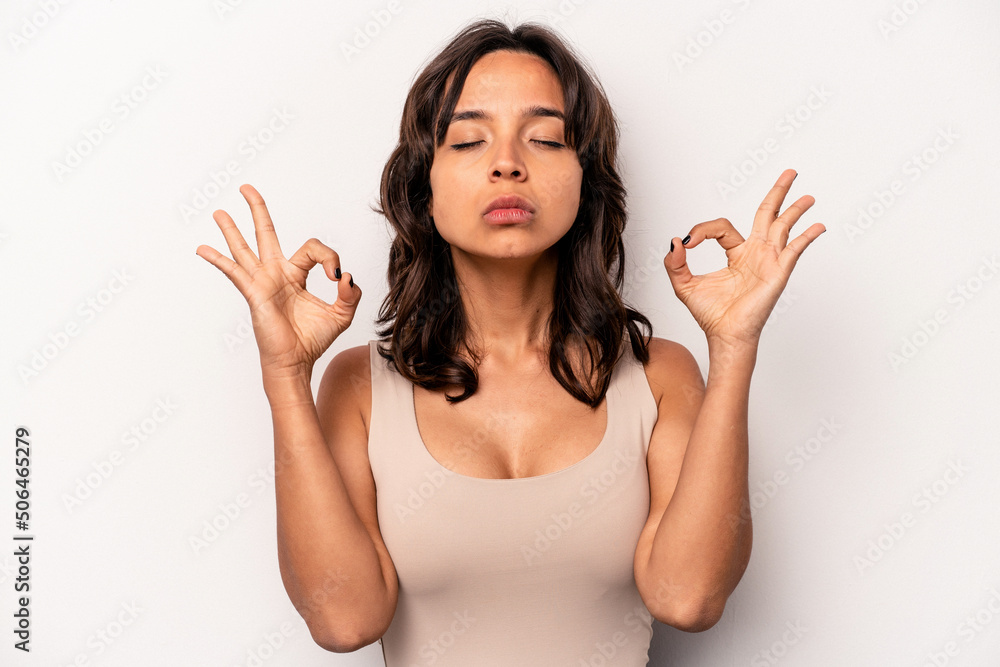 Young hispanic woman isolated on white background relaxes after hard working day, she is performing yoga. Young hispanic woman isolated on white background relaxes after hard working day, she is performing yoga.