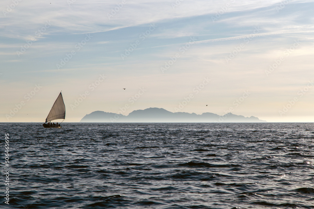 Barco de vela tradicional navegando. Al fondo se ven unas islas. Ría de Vigo, Galicia, España.