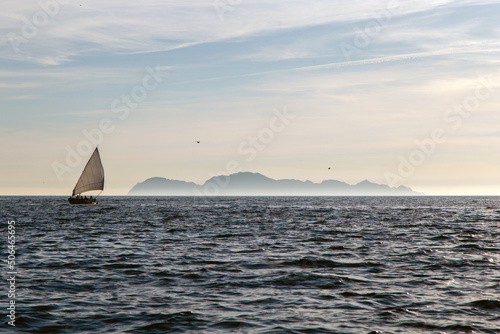 Barco de vela tradicional navegando. Al fondo se ven unas islas. Ría de Vigo, Galicia, España.