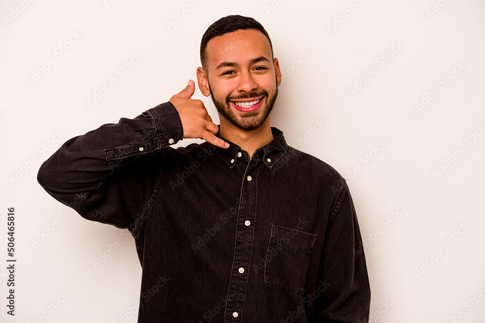 Young hispanic man isolated on white background showing a mobile phone call gesture with fingers. Young hispanic man isolated on white background showing a mobile phone call gesture with fingers.