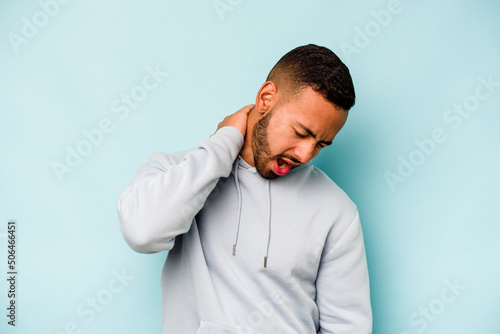 Young hispanic man isolated on blue background suffering neck pain due to sedentary lifestyle.