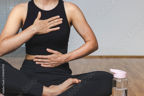 Woman doing breathing exercise sitting in lotus position. photo