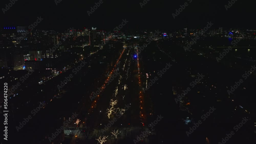 Forwards fly above night city. Wide straight street lined by street lights and with illuminated trees in middle. Boston, USA Forwards fly above night city. Wide straight street lined by street lights and with illuminated trees in middle. Boston, USA