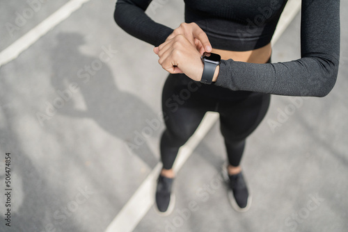 A smart watch with pulse and cardio, a female trainer trains outside in sportswear.