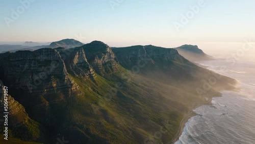 Amazing footage of mountains on sea coast. Green vegetation on slope rising from sea finished by rock wall on top. Cape Town, South Africa