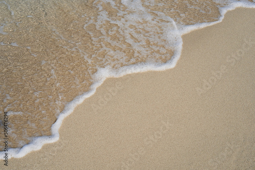 Close-up of the golden sand, washed by the gentle waves of the sea. Cala Mesquida, Majorca Spain
