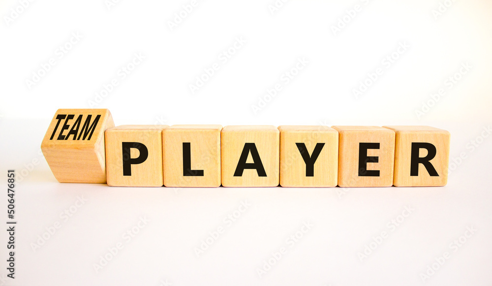 Player or teamplayer symbol. Turned wooden cubes and changed concept words Player to Teamplayer. Beautiful white table white background, copy space. Business player or teamplayer concept.