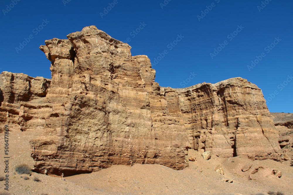 Fototapeta premium Beautiful sand and clay wall with reliefs in the Charyn canyon against a clear sky, summer, sunny