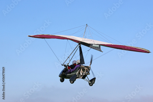 Ultralight airplane flying in a blue sky	