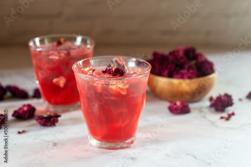 glass of rose Kombucha with iced on white table ,fermented tea drink, healthy beverage.