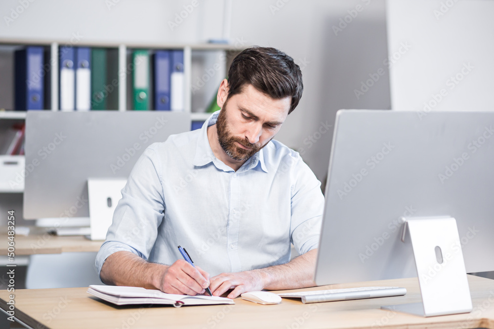 Confident business man stocks broker sitting in front of monitor screen in office analyzing stat of index charts data analyses market trend. Forex trading agency worker agent reviewing profits growth Confident business man stocks broker sitting in front of monitor screen in office analyzing stat of index charts data analyses market trend. Forex trading agency worker agent reviewing profits growth