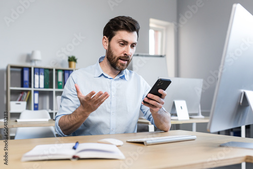 Photography surprised and shocked businessman in the office, man looks at the phone screen,