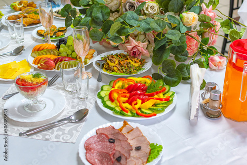 Beautiful festive wedding banquet table on which there are wine glasses and a delicious snack