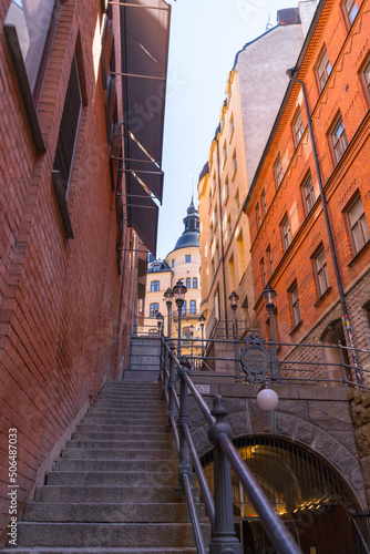 Stairs at the road Tunnelgatan with 1800s apartment houses with tin roofs  chimneys  dorms and towers down town a sunny day in Stockholm