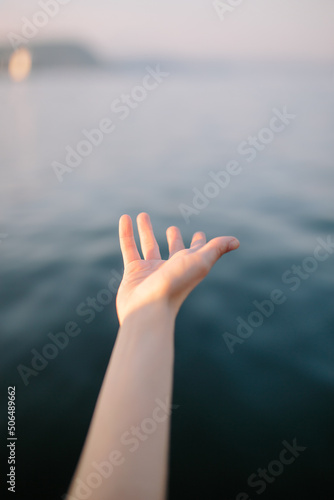 Hand of crop faceless lady against sea