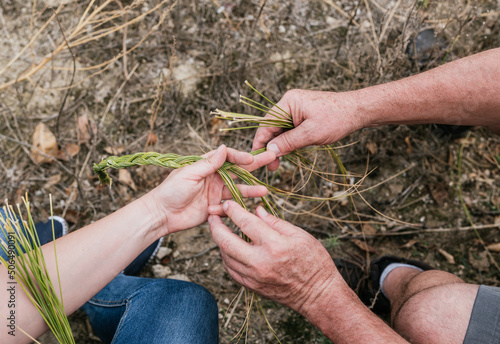 Woman with father holding halfah grass for natural fiber crafts photo