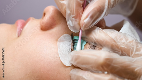 Obraz na plátně The master removes the composition for lamination from the client's eyelashes with a cotton swab