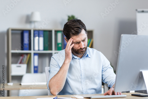 Wallpaper Mural Tired and annoyed young man, office worker, manager holding his head, feeling pain, dizziness