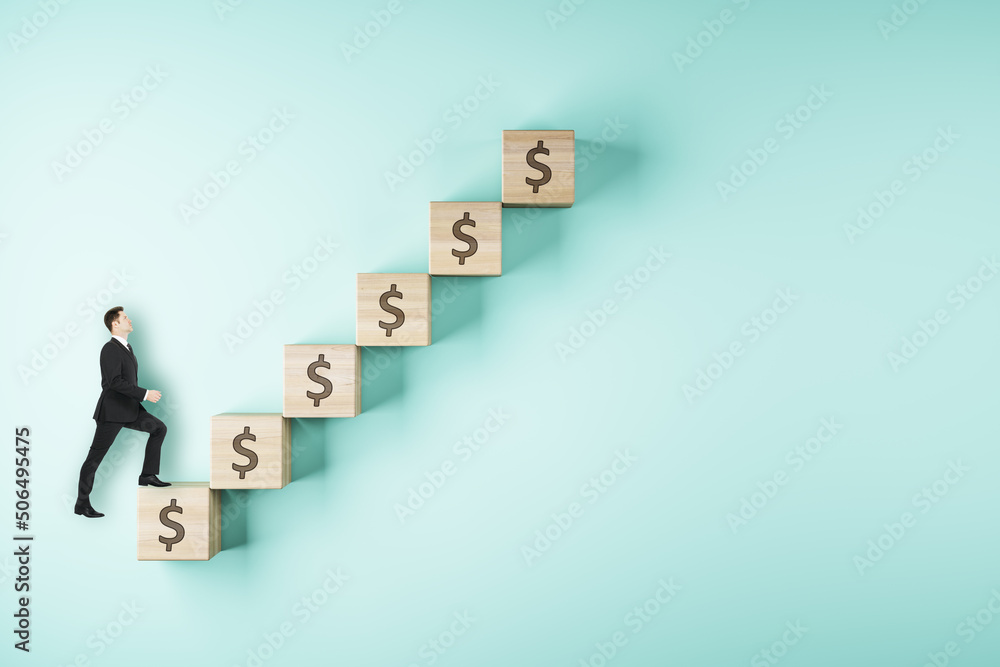 Career ladder and business success concept with businessman walks up wooden cubes arranged in a staircase on light blue backdrop Career ladder and business success concept with businessman walks up wooden cubes arranged in a staircase on light blue backdrop