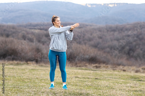 Sporty woman exercise and stretch in natural field before jogging