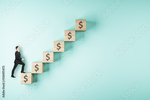 Career ladder and business success concept with businessman walks up wooden cubes arranged in a staircase on light blue backdrop © Who is Danny