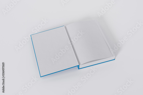 Mockup of a rectangular open on the first-page book with a blank, blue glossy cover on white background. Isolated with clipping path.