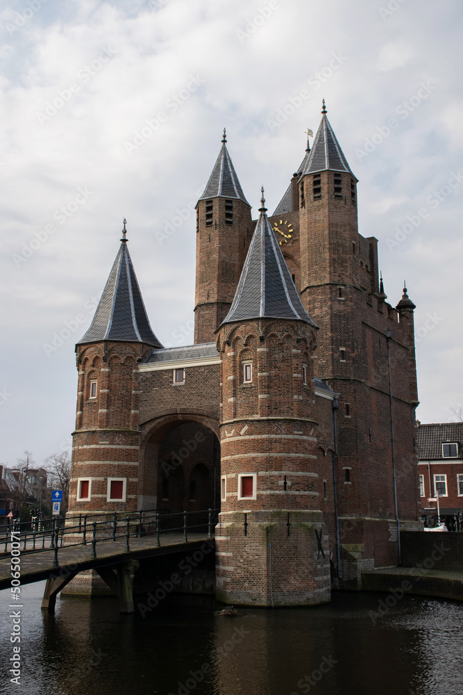 Fototapeta premium Historic city gateway at Haarlem in the netherlands. Famous travel destination. National monument. Defensive construction building. 