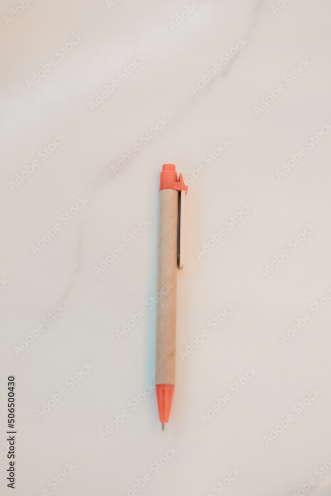 A written pen rests on a white background on the table A written pen rests on a white background on the table