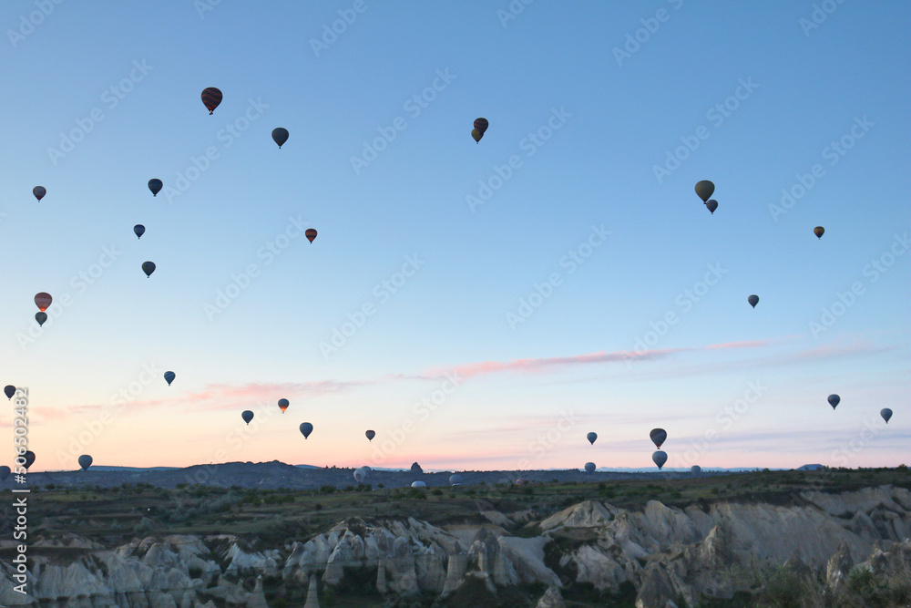 View of the city of Goreme with caves and air baloons in Cappadocia. Fabulous landscapes of the mountains of Cappadocia Goreme, Turkey