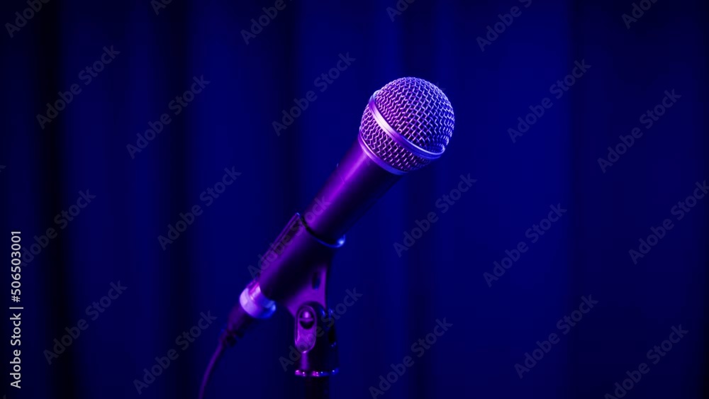 Microphone close-up, mic with blue neon light. Karaoke singing, nightlife club or bar. Music, musical concert. Microphone close-up, mic with blue neon light. Karaoke singing, nightlife club or bar. Music, musical concert.