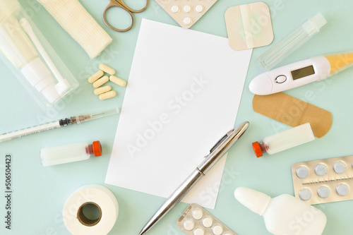 Top view of medical instruments: syringe, vaccine, pills, bandage, thermometer, workplace of medical personnel, an empty card with a place for text.