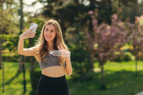 Sporty young girl with phone take selfie photo in the park