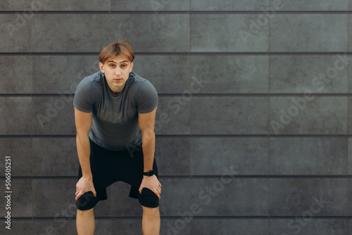 exhausted guy after training on a black wall