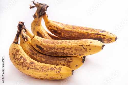 Very ripe bananas, almost spoiling pictured on white background, selective focus.