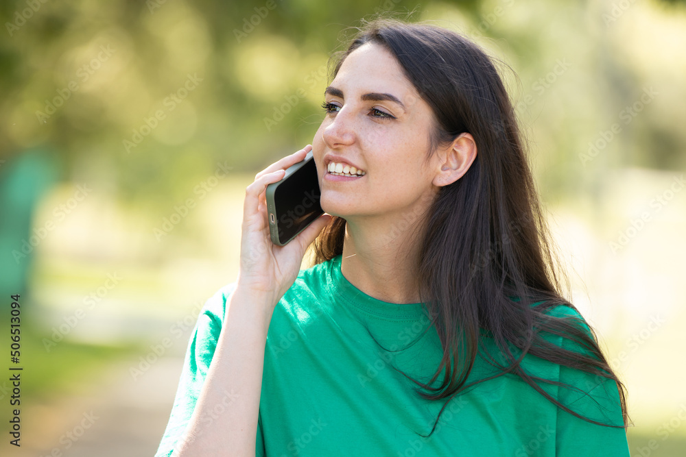 girl on the street in summer talking on a mobile phone girl on the street in summer talking on a mobile phone