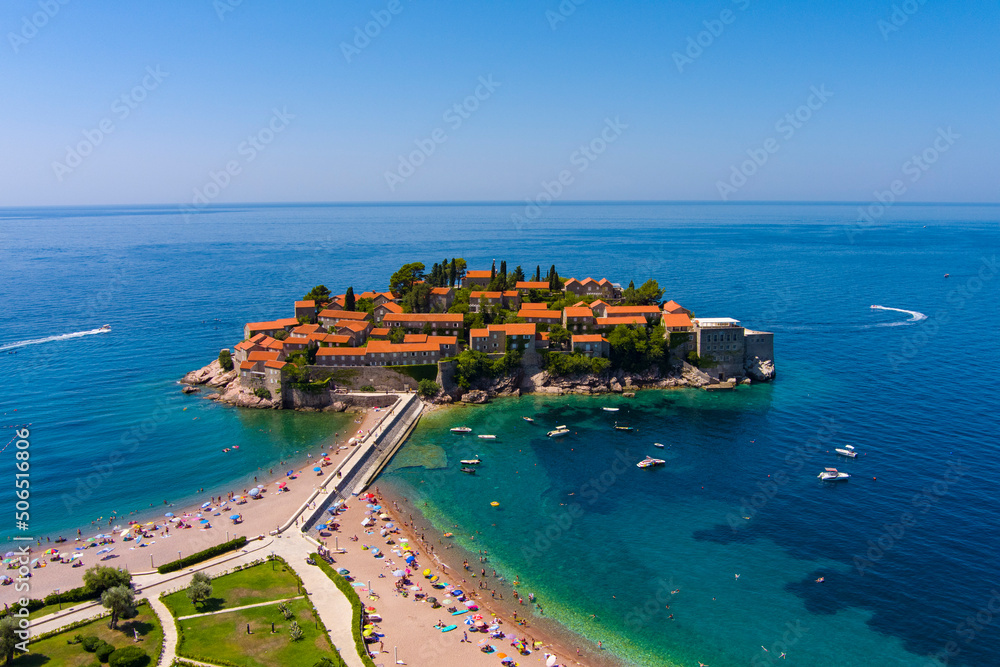Montenegro. Adriatic Sea. Island and beach of Sveti Stefan. Summer. Sunny weather. High season. A very popular tourist spot. Drone. Aerial view