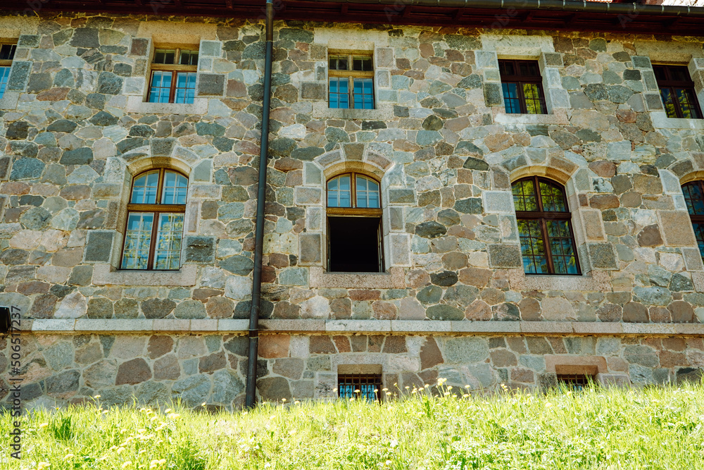 Fototapeta premium old castle stone wall with windows. one window open