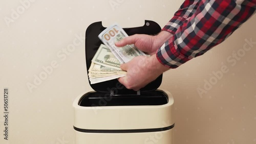 hand opens and throws american money into Sensory trash can. concept of inflation