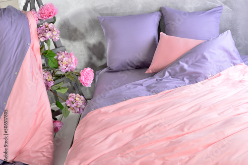 Bedroom with pink and purple bed linen, decorated with a ladder with flowers