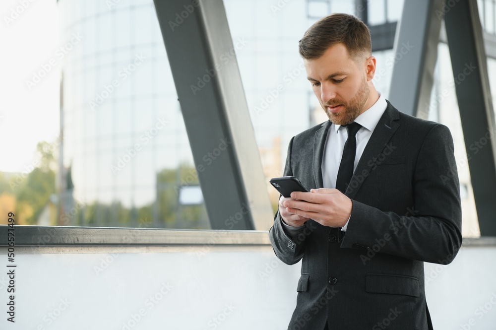 Stockbroker near the office. A successful and advanced handsome business man in a suit looks up in front of him standing on the background of concrete steps. Stockbroker near the office. A successful and advanced handsome business man in a suit looks up in front of him standing on the background of concrete steps.