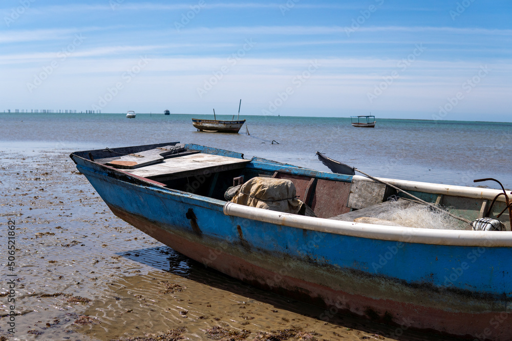 Ocean at low tide showing corals, rocks and small fishing boats in Bahia, Brazil, South America, Atlantic Ocean