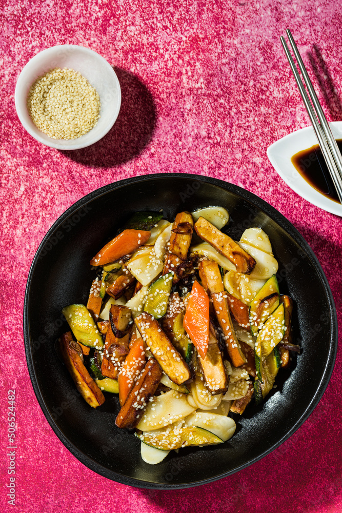 rice cake with vegetables in the plate. served with soy sauce