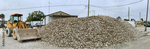 Large mound of shucked oysters with bulldozer in Apalachicola in north Florida on the Gulf of Mexico photo