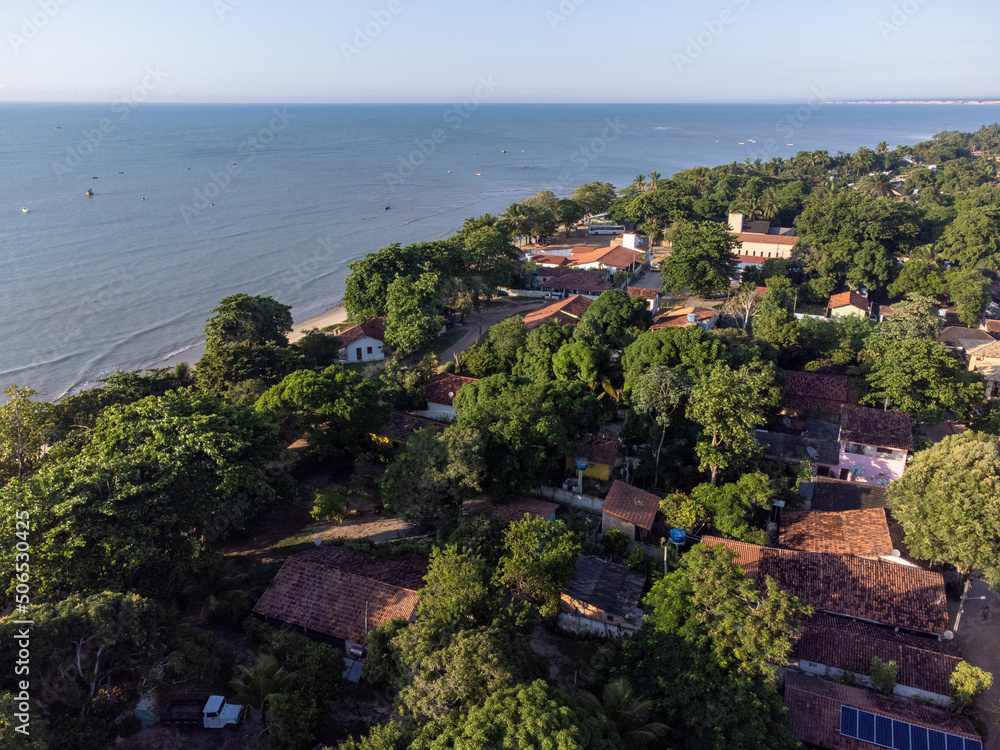 Wonderful city in the middle of the forest and Atlantic ocean with beautiful beach and low tide showing the corals - Cumuruxatiba, Bahia, Brazil - aerial drone view.